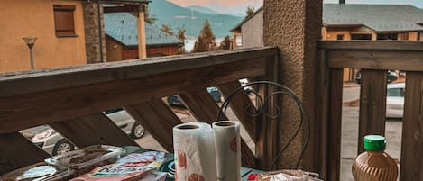 A table set outdoors with bread, a bottle, and a bottle of water.