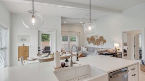 A modern kitchen with a central island, white cabinetry, and pendant lighting. - The Modern Cottage near 30a, Golf Cart + Bikes included! (Inlet Beach)