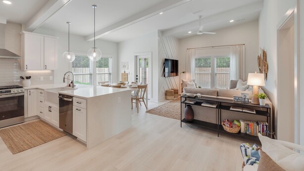 A spacious kitchen with white cabinets, a central island, and pendant lighting. - The Modern Cottage near 30a, Golf Cart + Bikes included! (Inlet Beach)