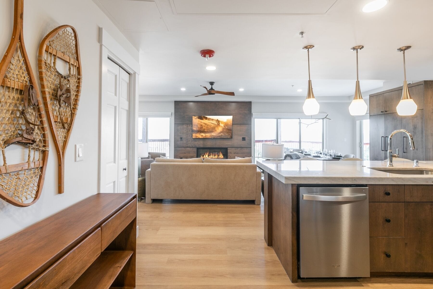 A modern kitchen with a central island, built-in appliances, and pendant lighting.