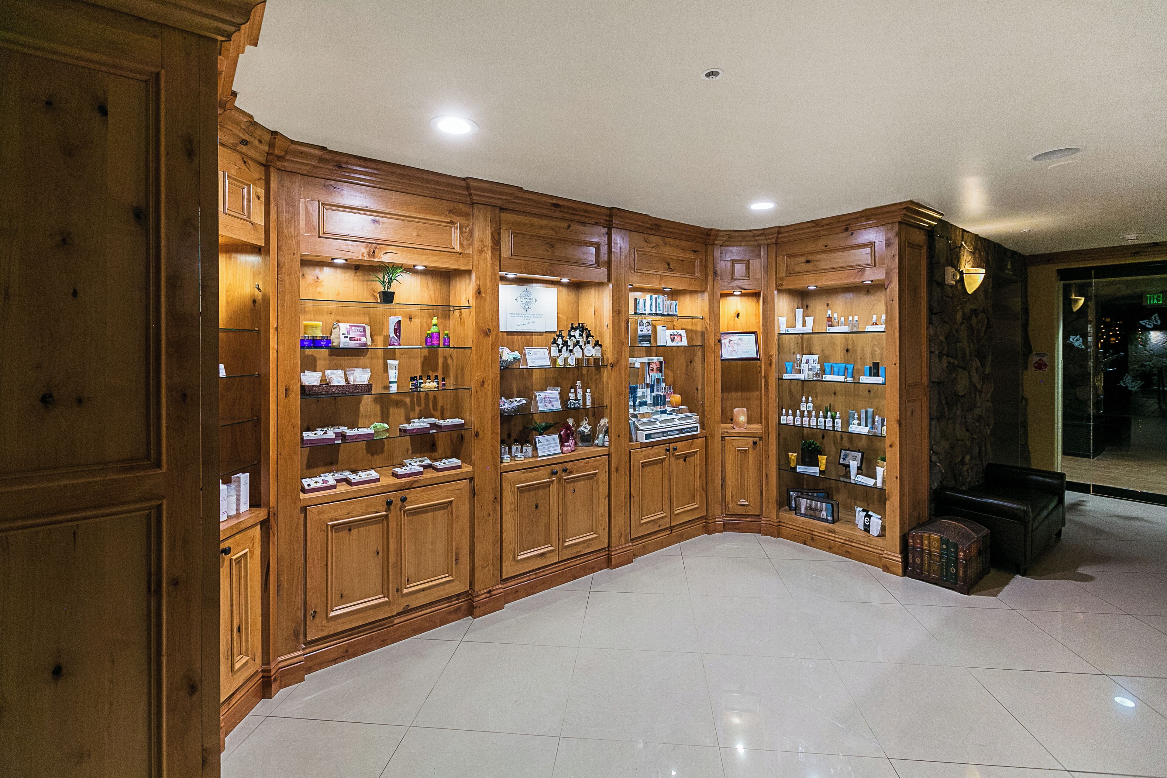 A spacious, well-lit room with wooden cabinetry and shelves displaying various items.