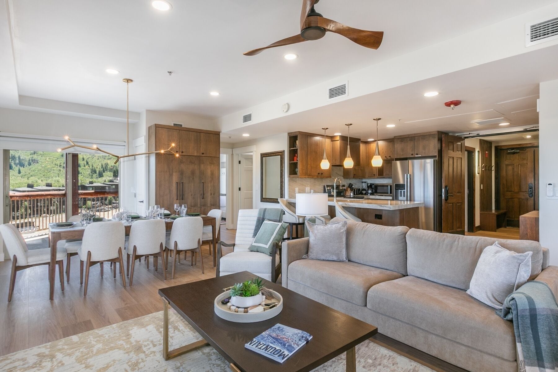 A modern living room with a sofa, dining area, and kitchen.