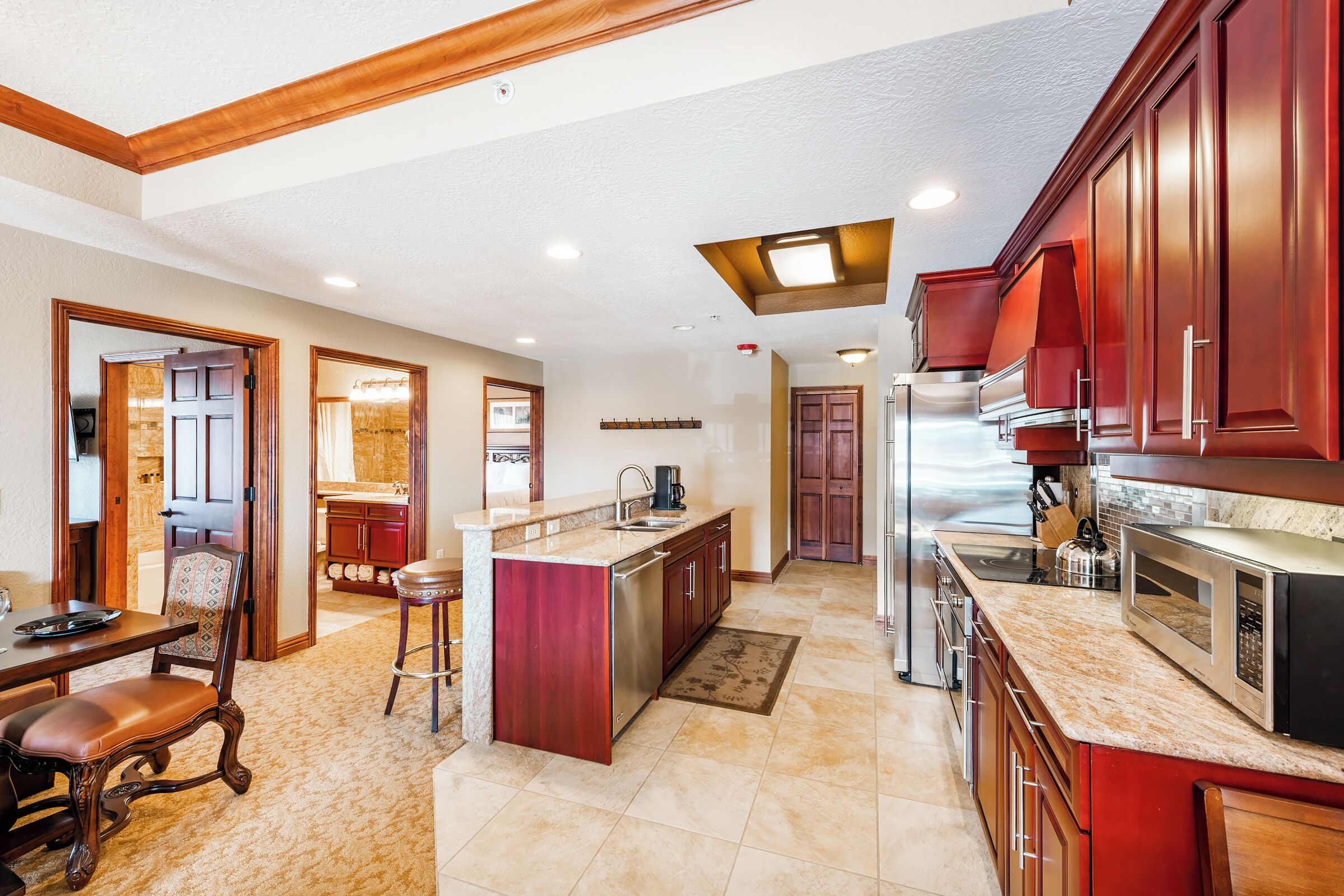 A spacious kitchen with a central island, wooden cabinets, and a dining area with a table and chairs.