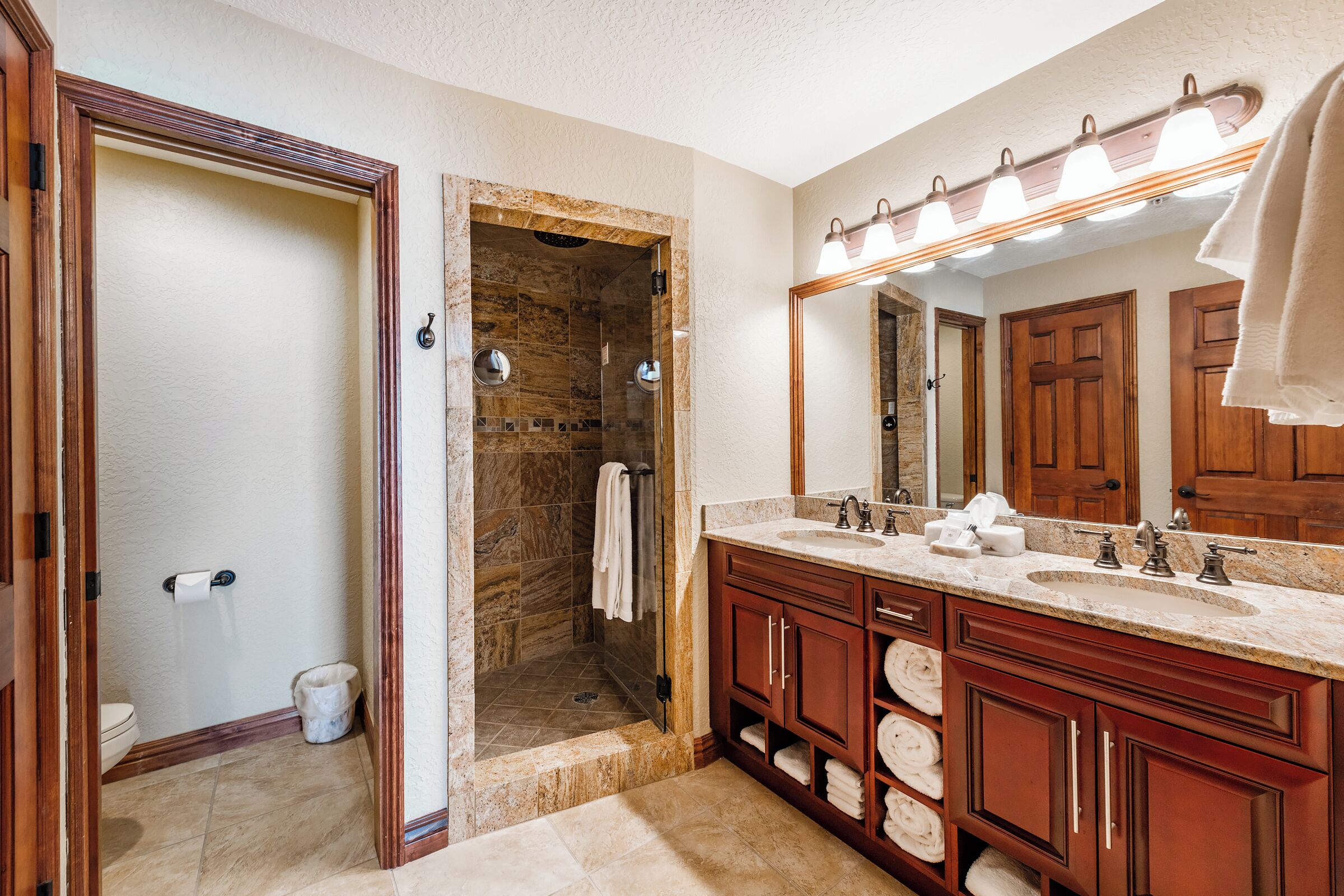 Un baño con ducha, lavabo y tocador.
