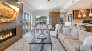 Una sala moderna con chimenea, comedor y cocina.