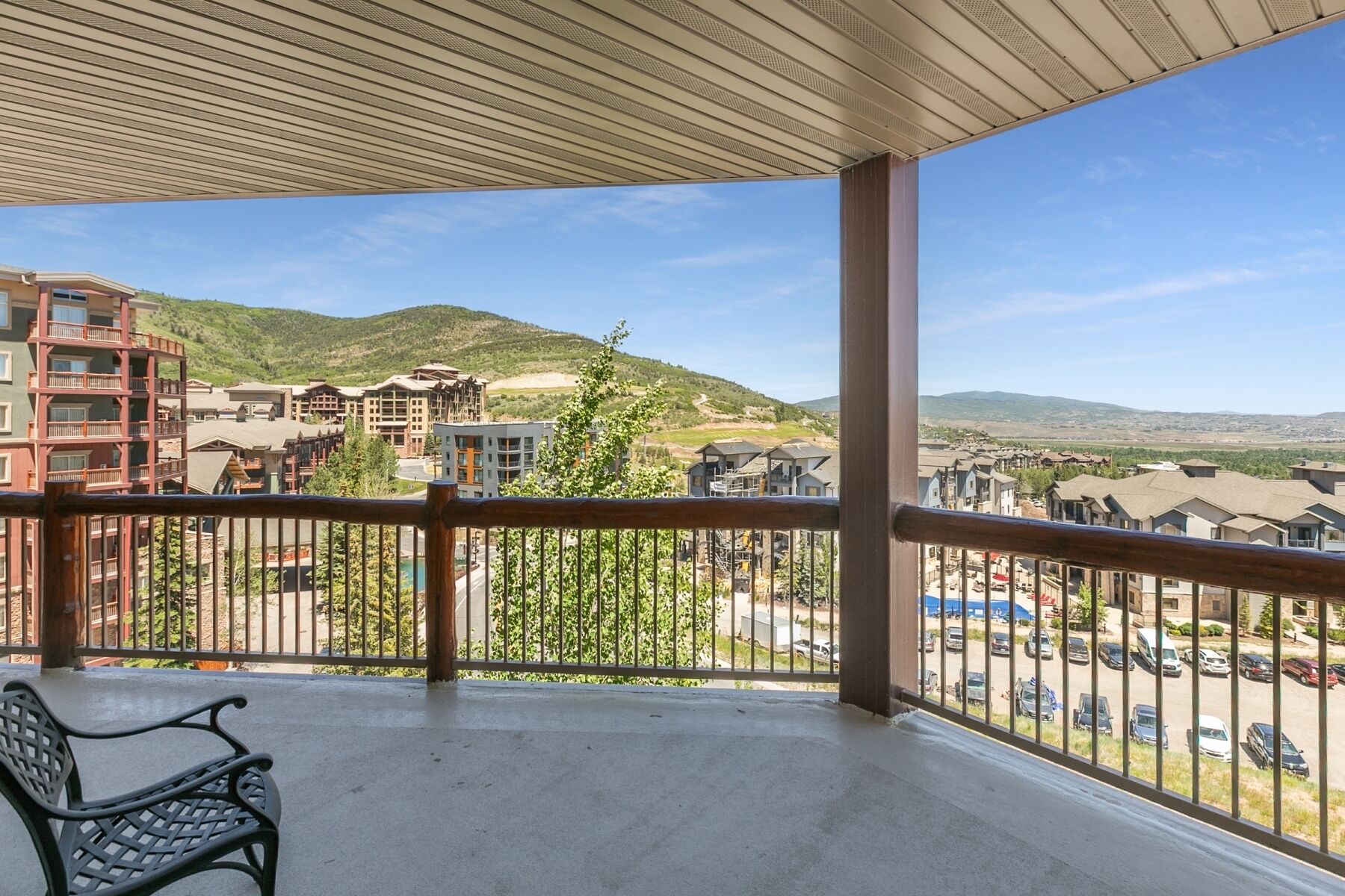 A balcony with a view of a residential area and hills.