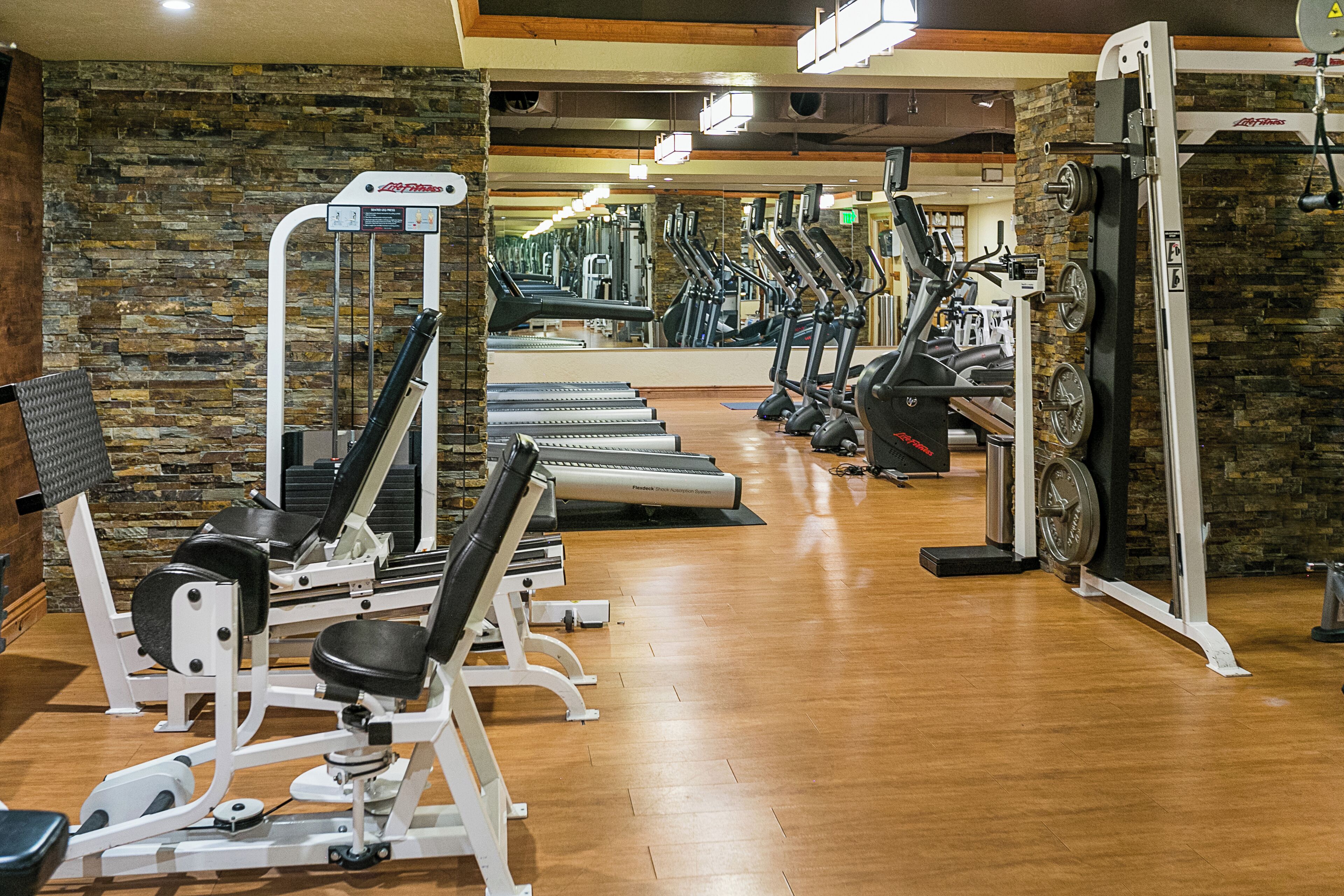 A gym with treadmills, elliptical machines, and weightlifting equipment.
