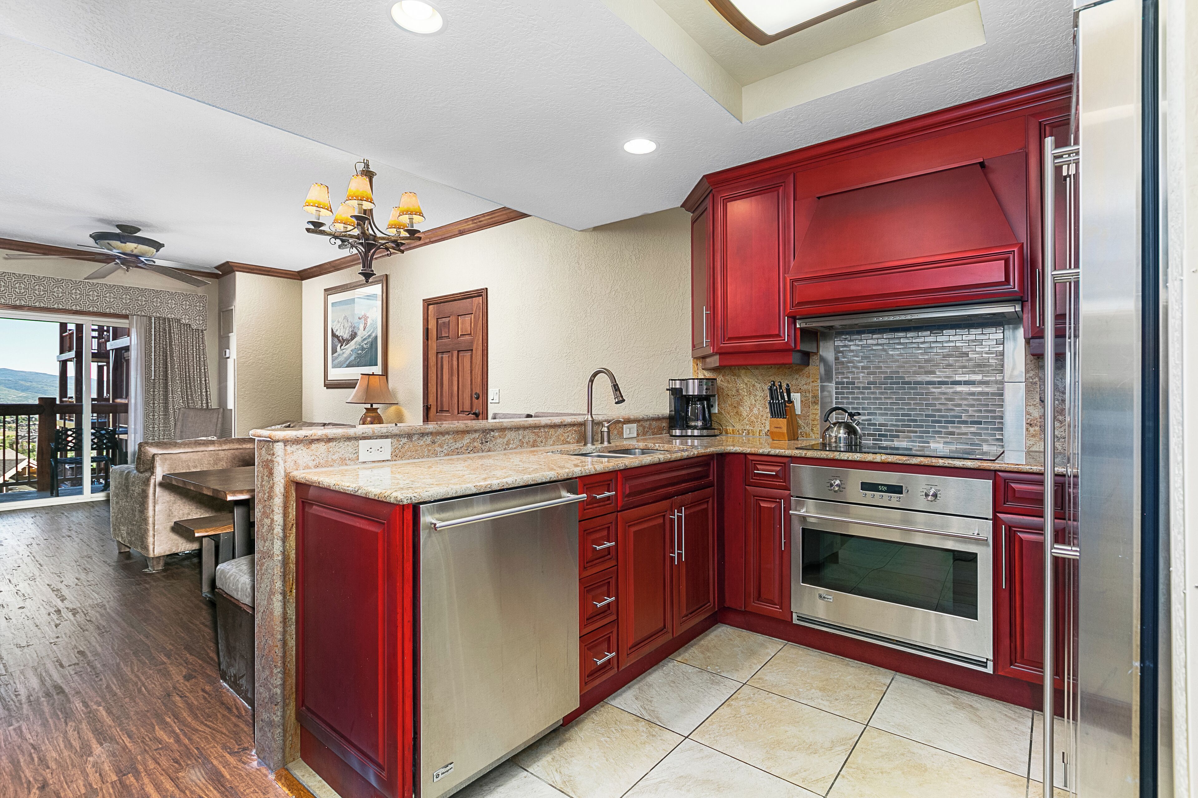 A kitchen with red cabinets, stainless steel appliances, and a large island.