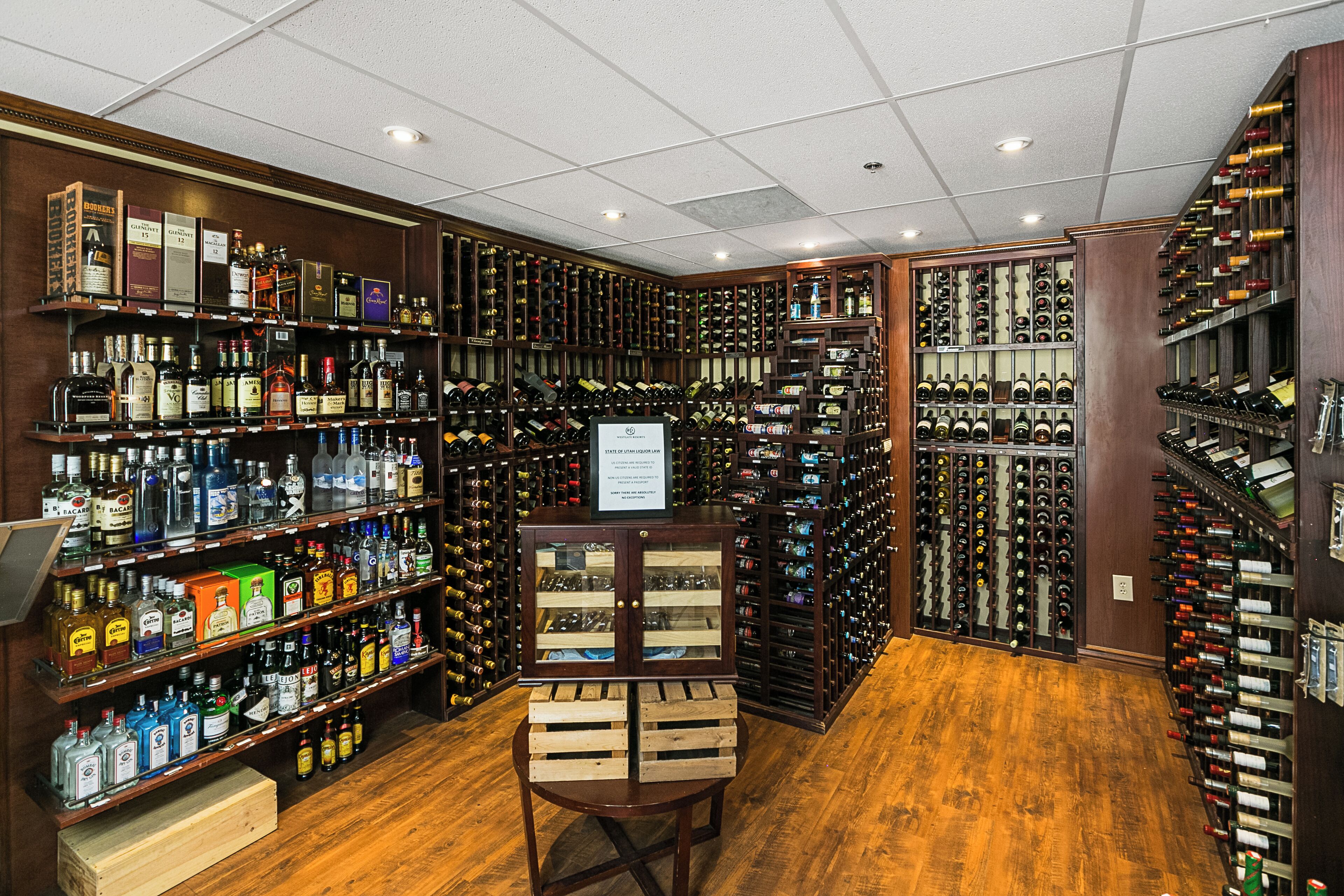 Une cave à vin avec des étagères et des supports en bois remplis de bouteilles.