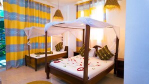 A four-poster bed with a canopy, two bedside tables, and a decorative pillow. - Green House Zanzibar (Nungwi)