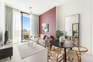Een moderne woonkamer met een bank, salontafel en een eethoek.