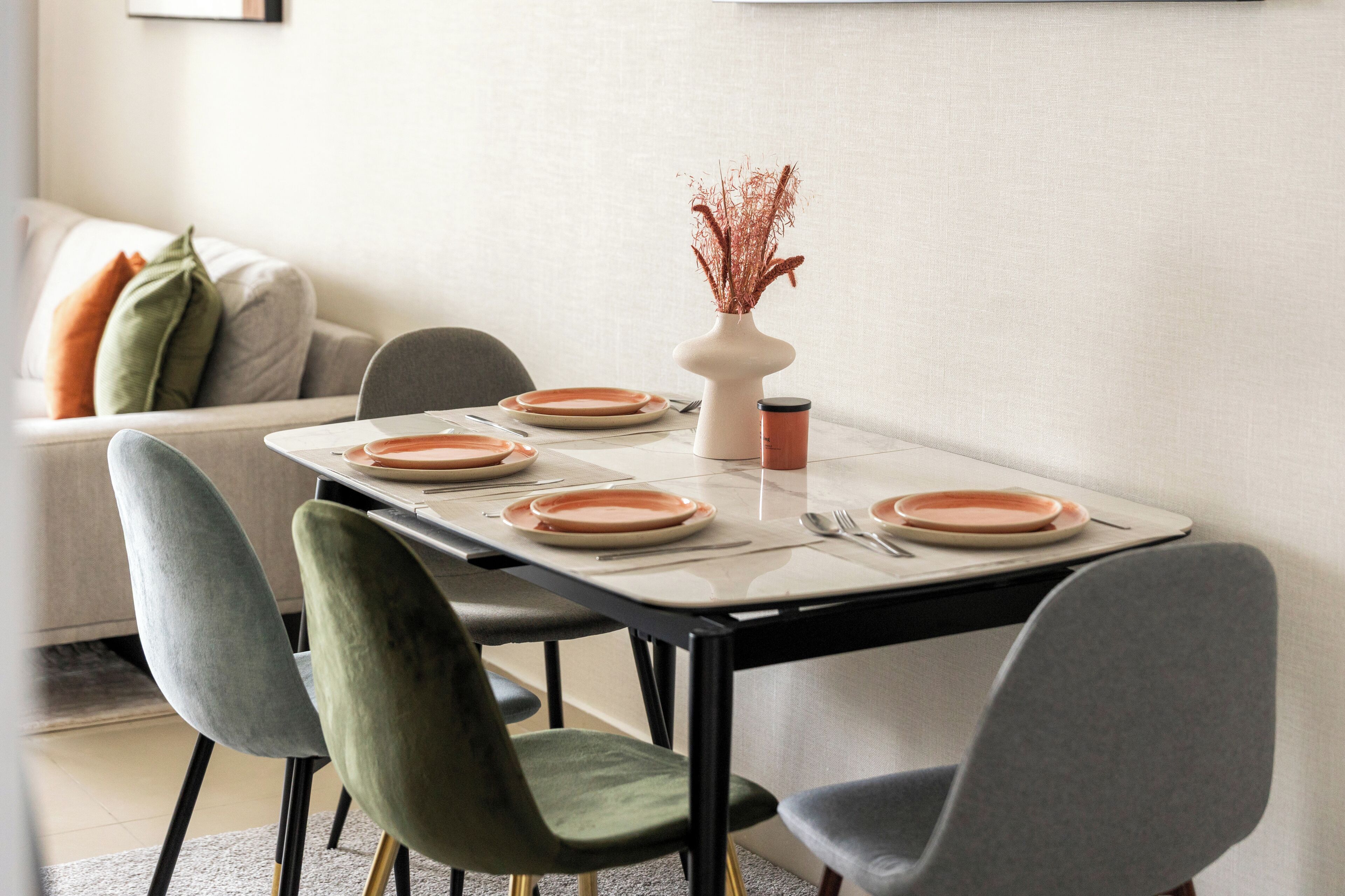 A dining table set with plates, a vase, and a cup.
