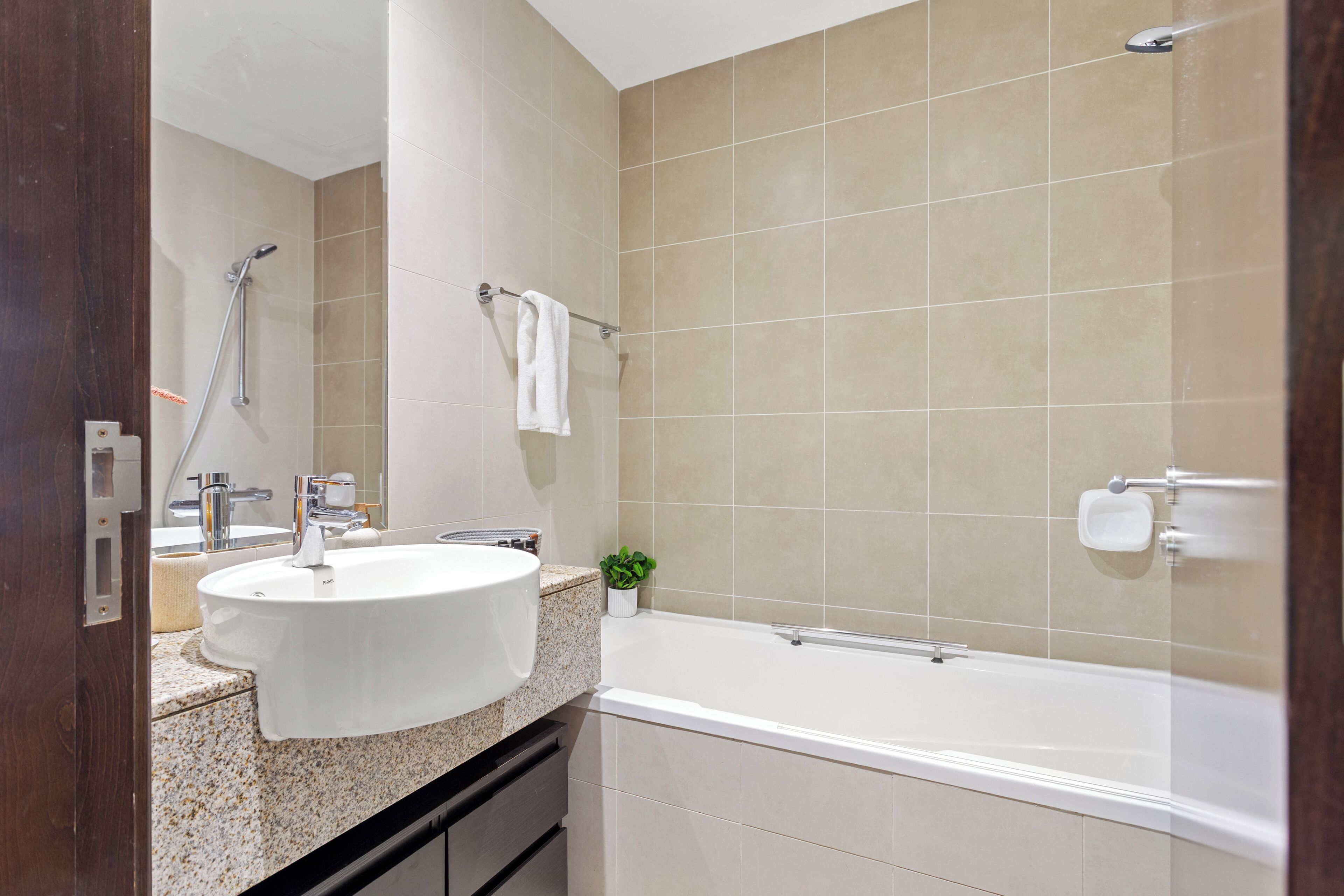 A bathroom with a sink, mirror, towel rack, shower, and bathtub.