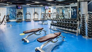A gym with exercise equipment, benches, and a wall with motivational text. - Silkhaus Amwaj 4 (Dubai)