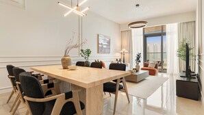 Un comedor moderno con una mesa de madera, sillas tapizadas en negro e iluminación contemporánea.