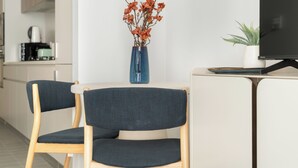 Une cuisine moderne équipée d’une machine à café, d’un vase avec des fleurs et d’un téléviseur posé sur un meuble.
