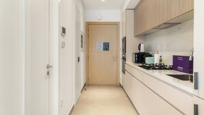 Une cuisine moderne avec une porte en bois, une machine à café et un évier.