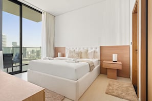 A modern hotel room with a large bed, a bedside table, a view of the city through floor-to-ceiling windows, and a small balcony.