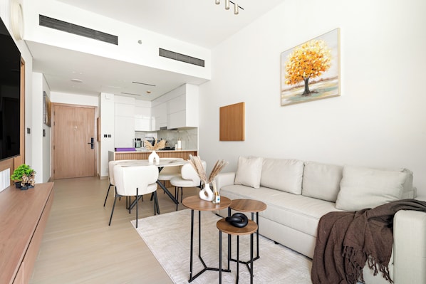 A modern living room with a sofa, coffee table, and dining area.