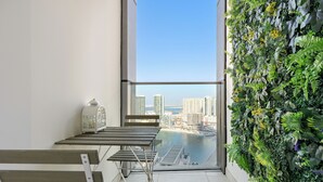 Een balkon met uitzicht op een stadsgezicht en een groene wand.