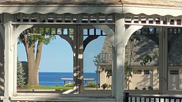 Ein Pavillon mit Blick auf das Meer und einem Haus im Hintergrund.