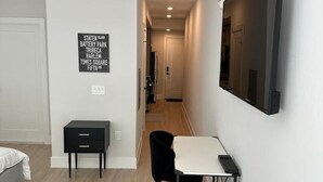 Un dormitorio moderno y minimalista con una cama, un escritorio y una silla.
