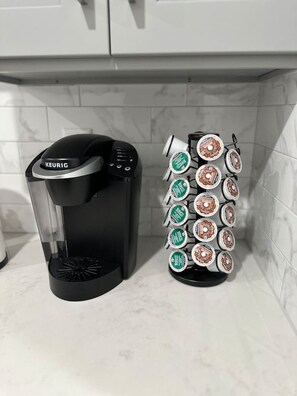 Eine Kaffeemaschine von Keurig und ein Kaffee-Pad-Spender in einer Küche.