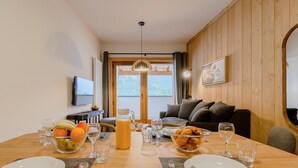 A dining area with a wooden table set for breakfast, including fruits, pastries, and beverages. - Wifi, 300m from resort center, balcony, parking, tv, ski locker, 39-46m², Champagny-en-Vanoise (Champagny-en-Vanoise)