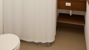 A bathroom with a shower curtain, a sink, and a toilet. - Barmel Apartments (Coxen Hole)