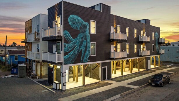 A multi-story building with a unique exterior mural of a figure in flowing robes.