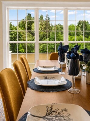 A dining table set for four with plates, glasses, and napkins. - Lakefront Home, Hot tub, Fire Pit, Game Room, & Movie Room! (Marion)