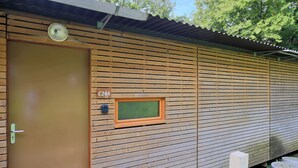 A wooden cabin with a door, a small window, and a label 'C24A'. - Les Charmes C24B - Le Val Joly (Eppe-Sauvage)