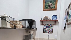 Una cuina compacta amb taulell de fusta, rentaplats integrat i un rentamans.