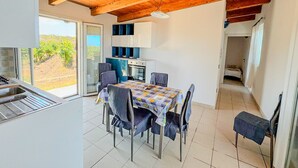 Una cocina moderna con comedor, vigas de madera en el techo y vistas al exterior.