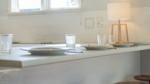 Een keuken met een wit aanrecht, een raam en een lamp.
