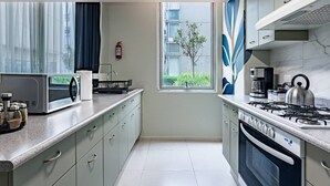 Una cocina moderna con estufa a gas, microondas y electrodomésticos de acero inoxidable.