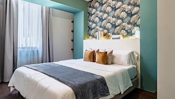 Ein Schlafzimmer mit einem Bett, Vorhängen, blumigem Wandpapier und einem Fenster.