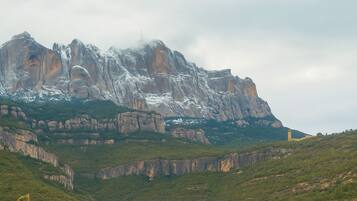 Paesaggio montuoso con una roccia imponente e una piccola torre.