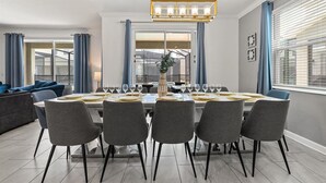 Un comedor moderno con una mesa rectangular dispuesta para seis personas, rodeada de sillas grises.