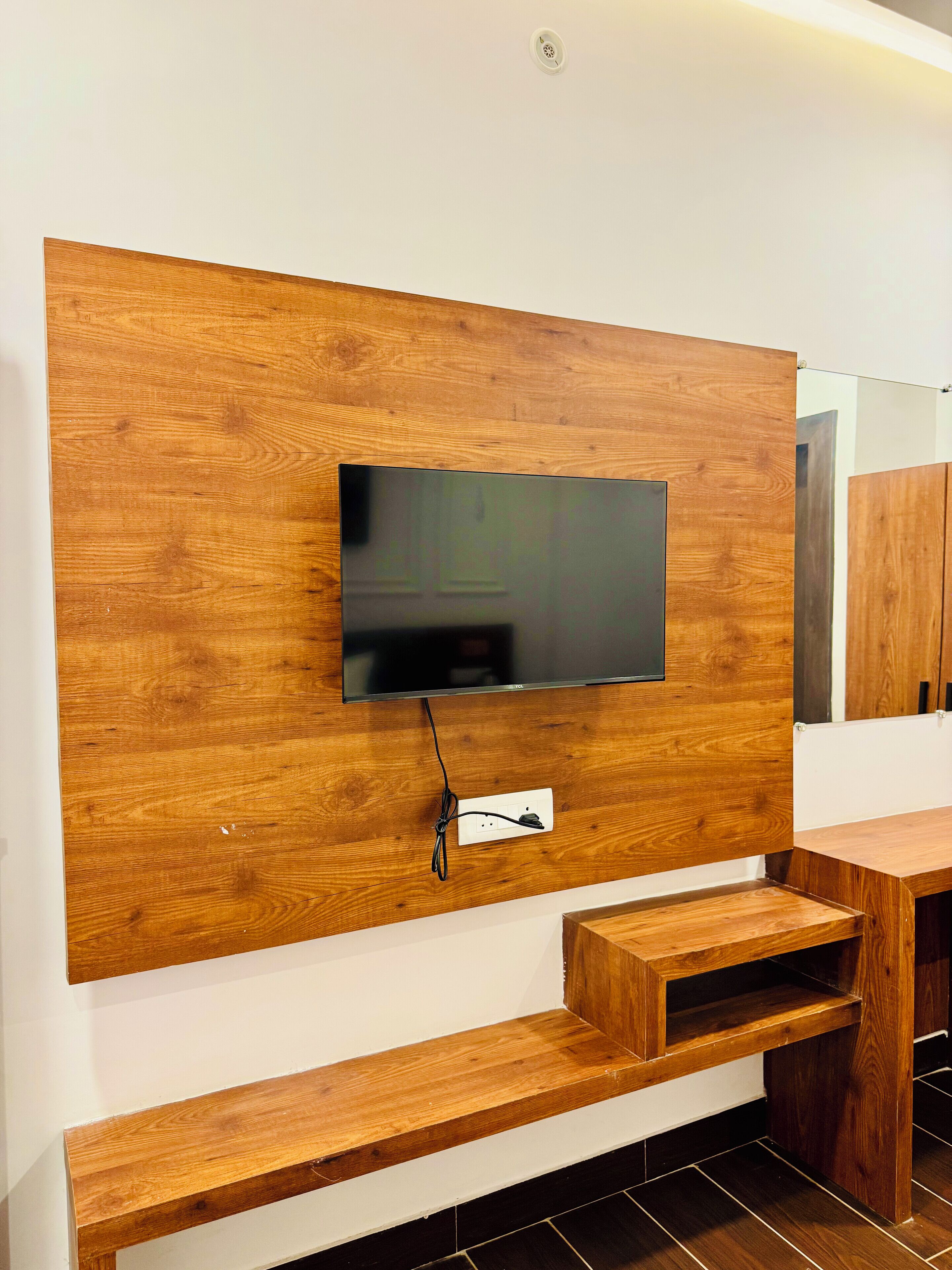Un salon moderne avec un meuble mural en bois, un téléviseur à écran plat et des bancs en bois intégrés.
