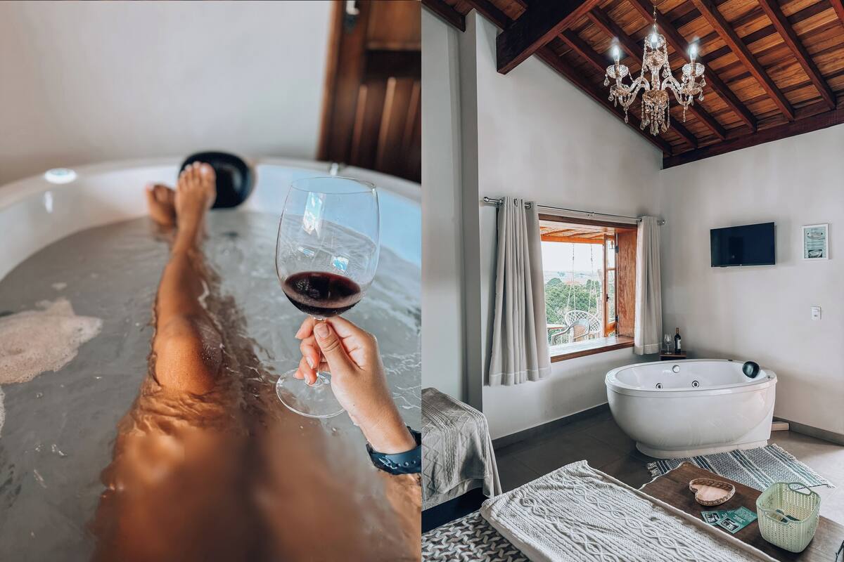 A room with a bathtub, a wooden ceiling, and a chandelier.