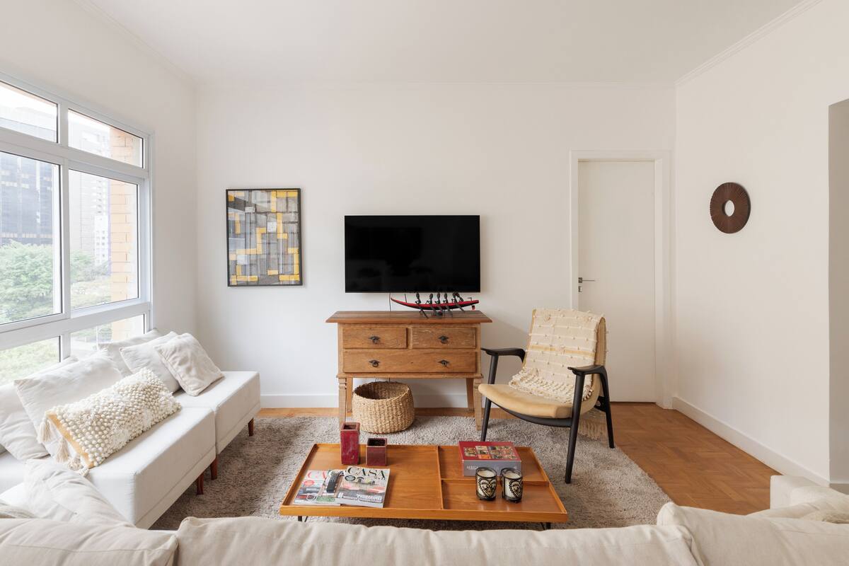Ein modernes Wohnzimmer mit Sofa, Couchtisch und Fernseher.