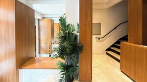Un couloir moderne avec un lambris en bois, un escalier et une plante en pot.
