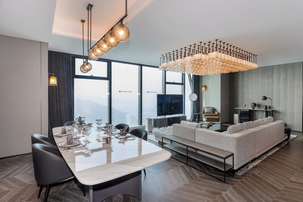Una sala de estar moderna con comedor, ventanas amplias y una televisión.