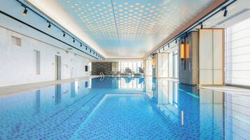 Innendørsbasseng, solsenger og badevakt