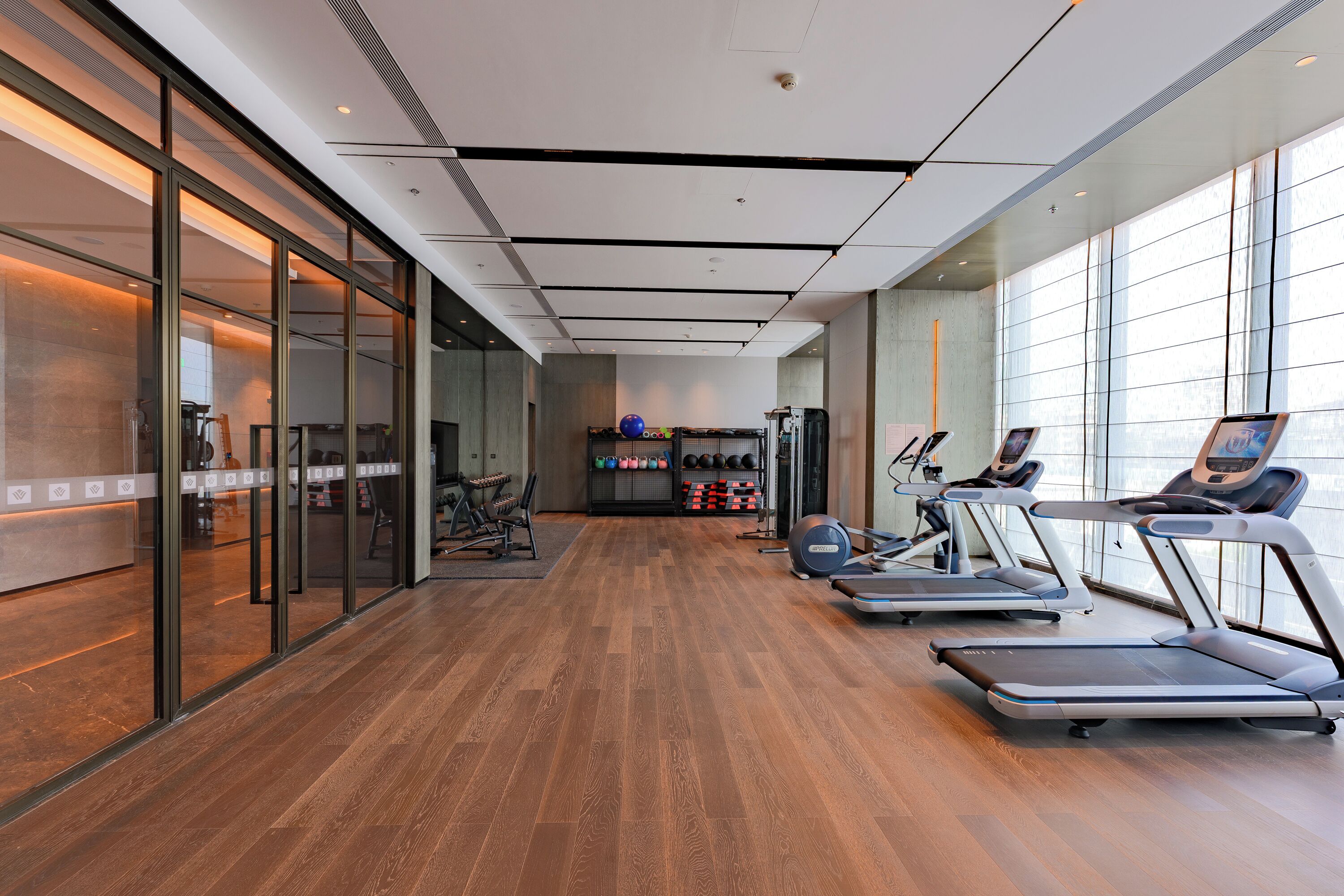 A gym with treadmills, exercise balls, and weights.