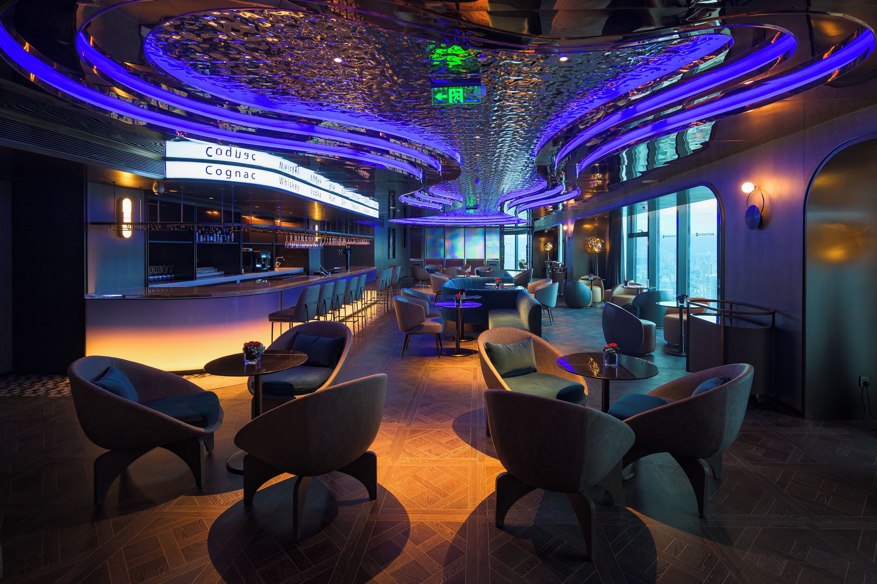 A modern interior with a bar area, seating, and a ceiling with a unique design.