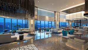 Un vestíbulo amplio con techos altos, ventanas grandes y diseño moderno.