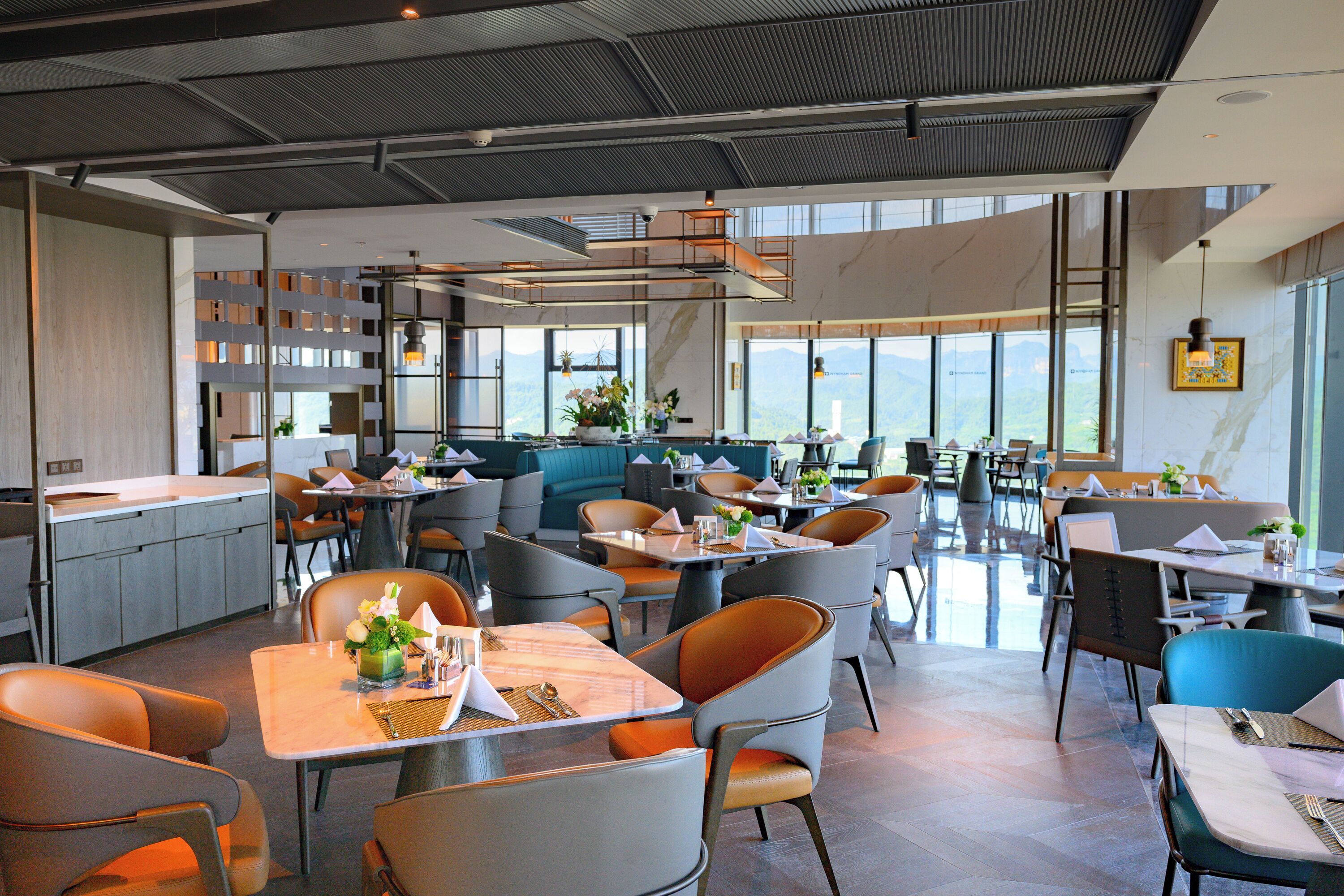 A modern restaurant with high ceilings, large windows, and a variety of seating arrangements including tables and booths.