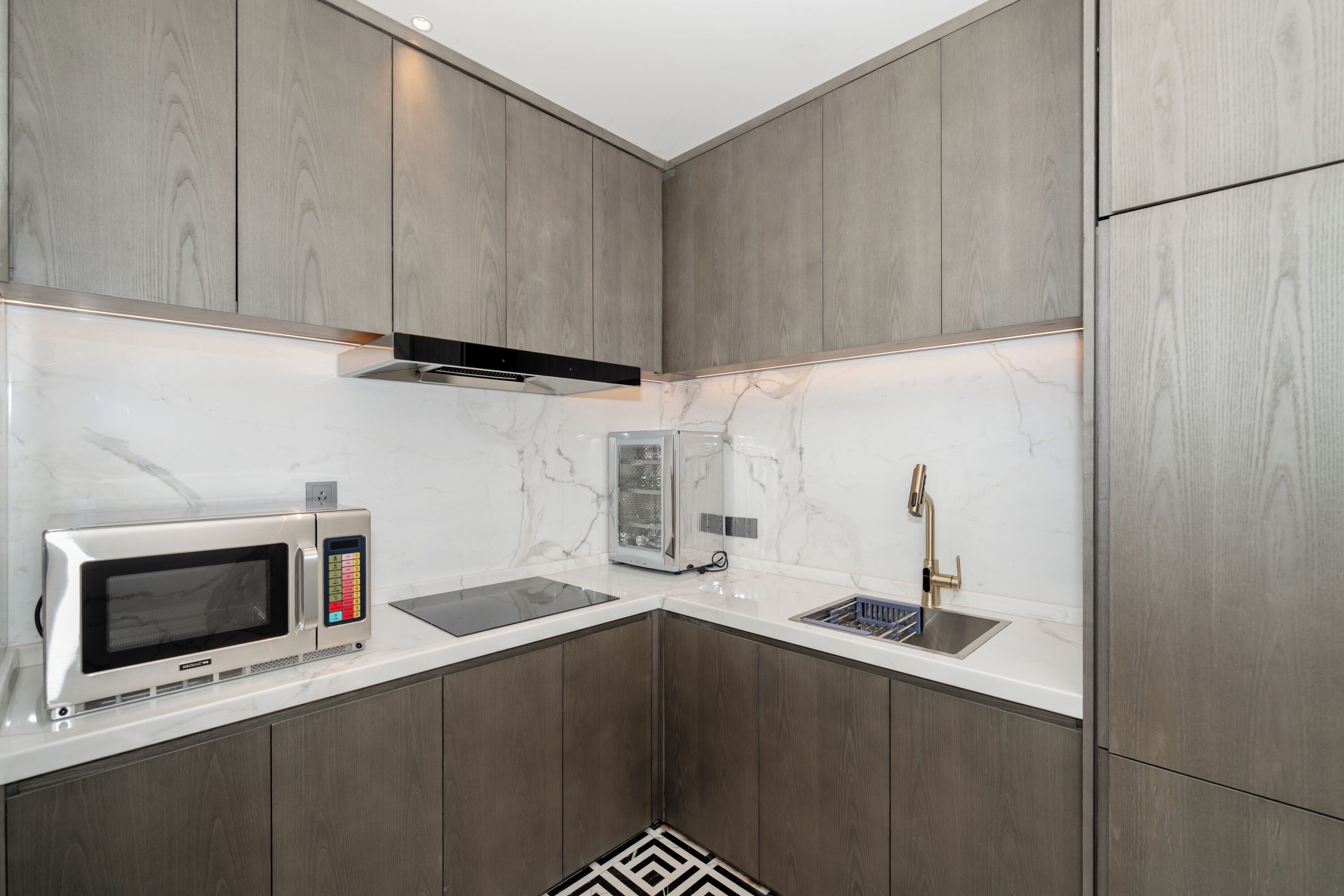 Una cocina moderna con armarios de madera, microondas, tostadora y fregadero.